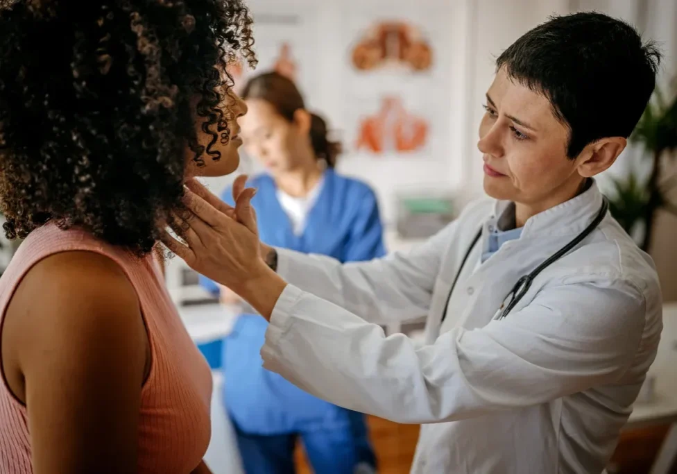 Doctor examining patient's throat in a clinic.
